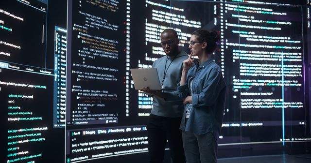 Image showing two data scientists with a large screen of data in the background. List image for: How can generative AI help standardise data in the VCM?