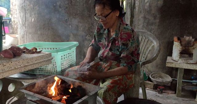 Image of someone cooking with an open flame. Cookstoves in the VCM