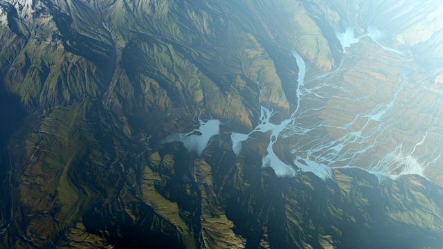 Satellite image of hilly/mountainous region with water running off into large tributaties